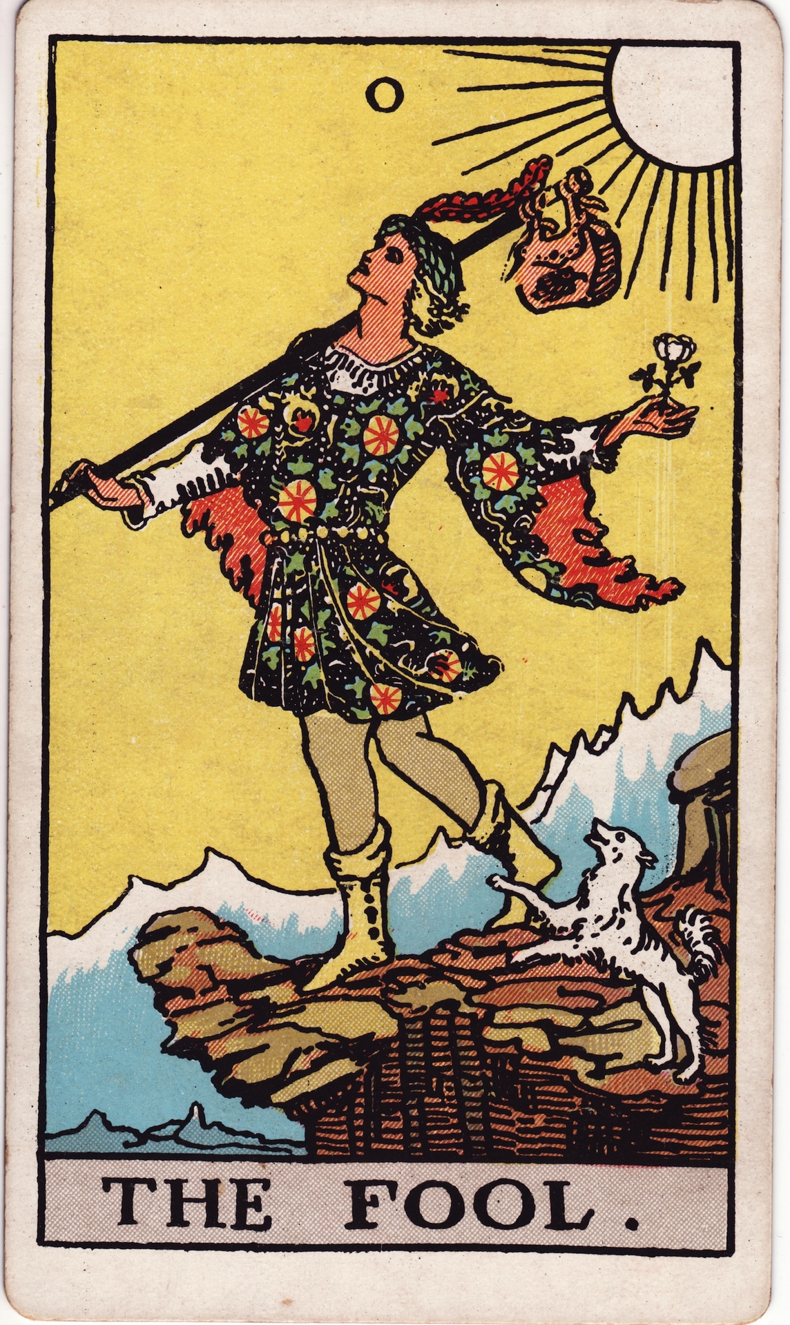 Le Mat du tarot Rider-Waite-Smith, un jeune voyageur au bord d'une falaise, une rose blanche à la main, un petit chien à ses pieds