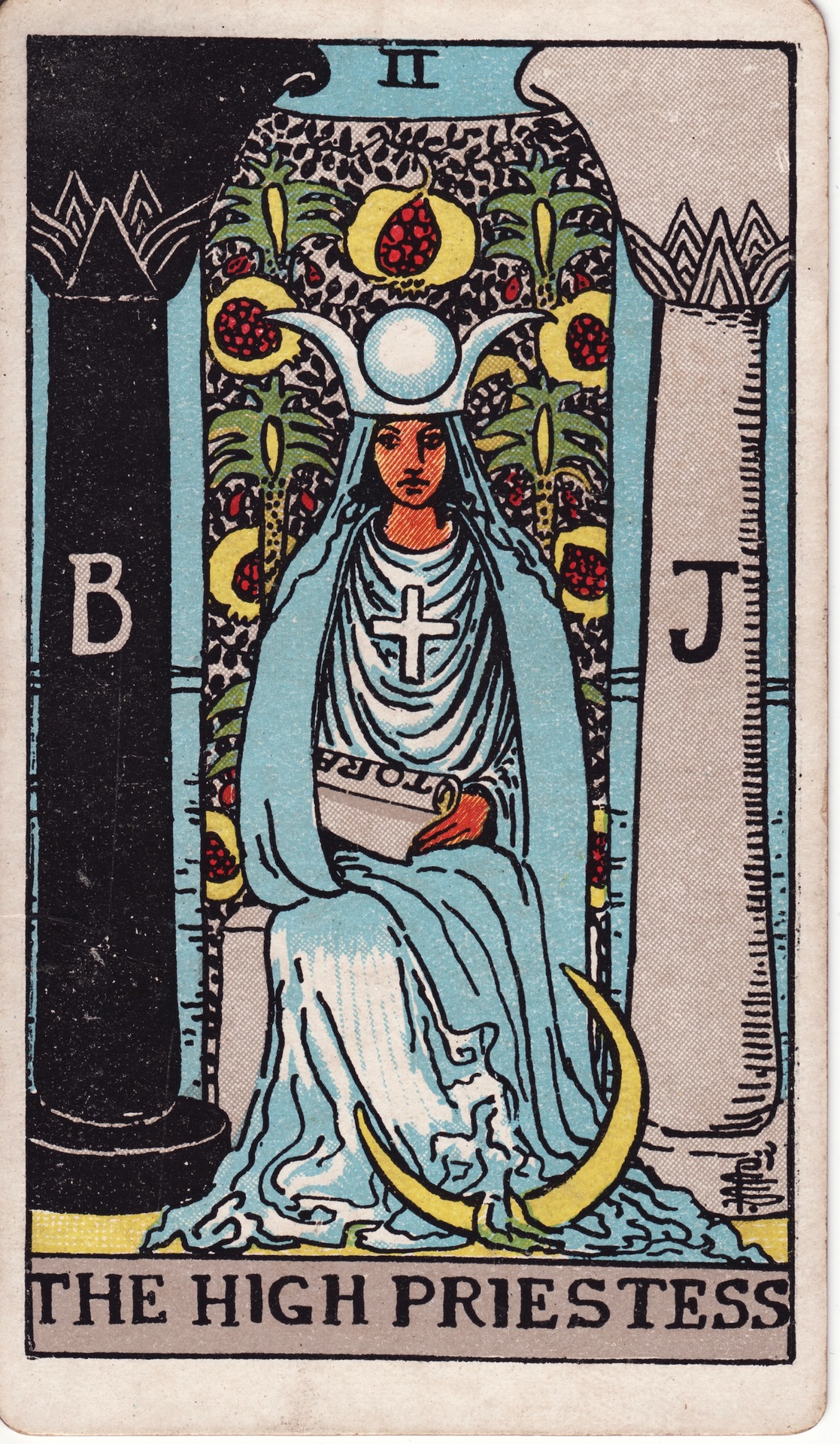 La Grande Prêtresse du tarot Rider-Waite-Smith, assise entre deux colonnes marquées B et J, devant une tenture de grenades