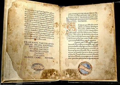 Livre ancien ouvert : première édition imprimée de la traduction latine du Corpus Hermeticum par Ficin, avec une lettrine dorée