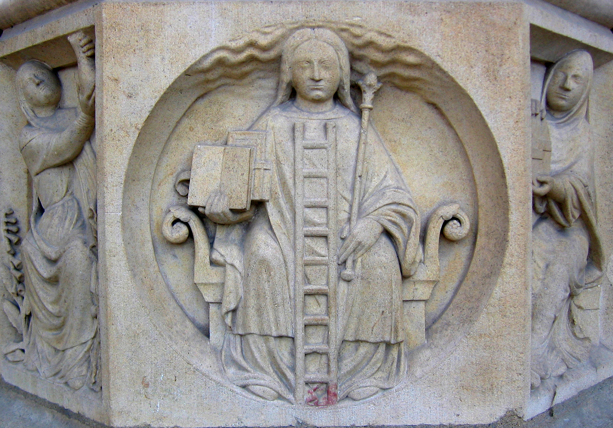 Relief du portail central de Notre-Dame de Paris : une femme assise tient un sceptre, une échelle appuyée contre elle, deux livres à la main